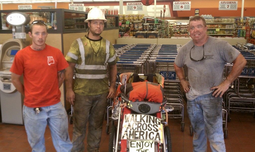 Chris, Dylan and Casey, at the grocery store in Valley, AL. The three form part of a construction crew that is working on doubling the width of a bridge across a small river, half a block from the store. I had to narrowly squeeze by in the two open lanes of the bridge, and is generally the case while walking through road construction, workers see my matching traffic safety vest and stare at me. As is the case with all others, I'm also always enthusiastic to chat with those in matching vests.    Casey and Chris each wanted to contribute a number of meals for me down the road, and did just that... Nice guys!
